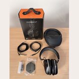 Na fotografii je sada sluchátek s příslušenstvím. Je zde černý papírový box s oranžovým vrchem a nápisy CROSSFADE LP2, milano design a vmoda. Součást…