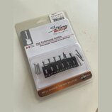 Plastové balení s náhradními kobylkovými sedly a šrouby. Na obalu je nápis String SAVER, High Performance Saddles, Dramatically reduces string breaka…