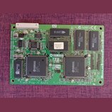 Zelená elektronická deska s osazenými čipy a součástkami. Na desce jsou viditelné nápisy YAMAHA, AP for XG a Plug for XG. V dolní části je text Piano…