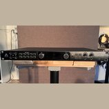Černý rackový audio rozhraní s nápisem APOGEE a logem vlevo a názvem ensemble Thunderbolt Audio Interface vpravo. Přední panel obsahuje několik vstup…