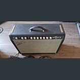 Černý kytarový kombo zesilovač s šedým textilnímkrytím reproduktoru. Na přední straně je nápis Fender a v pravé části modelové označení Super Sonic s…