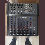 Černý mixovací pult s nápisem MULTIMIX8 USB FX a logem ALESIS. Zařízení obsahuje čtyři mikrofonní vstupy, linkové vstupy, různé ovládací prvky v podo…