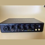 Černý zvukový interface s nápisem TERRATEC na horní straně. Na předním panelu jsou knofíky s popisky MIC INPUT, HEADPHONE, GAIN 1, GAIN 2, PHONO IN a…