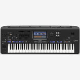 Černý digitální klavír s nápisy Genos a YAMAHA. Nástroj disponuje displejem, několika řadami tlačítek, posuvníkymi a standardní klaviatura. Povrch je…