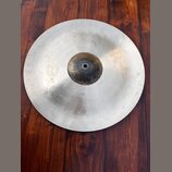 Kruhové činely z kovového materiálu s matným povrchem a tmavším středem. Na levé straně je viditelné logo Meinl. Povrch vykazuje drobné nečistoty a z…