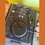 Černý digitální DJ player s nápisem gemini a označením CDJ-300 Professional Media Player. Zařízení obsahuje jogové kolo, fader a řadu ovládacích tlač…