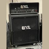 Černý kytarový zesilovač s boxem značky ENGL. Horní kombo má na ovládacím panelu nápisy Input, Gain, Bass, Middle, Treble, Presence, Master A, Master…