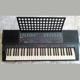 Černý elektronický klavír s nápisem YAMAHA PSR-400 a označením AWM. Nástroj má standardní klávesnici s bílými a černými klávesami, v levém dolním roh…
