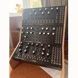 Tři černé modulační syntetizátory značky moog umístěné v dřevěném stojanu. Horní jednotka nese nápis SPECTRAVOX SEMI MODULAR SYNTHESIZER, prostřední…