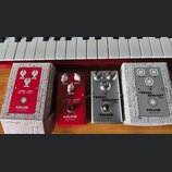 Čtyři kytarové efekty značky NUX z řady Reissue Series. Dva červené pedály mají nápis XTC OD, jeden stříbrný pedal má nápis STEEL SINGER DRIVE a posl…