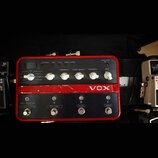 Červený efektový pedál značky VOX s kovovým šasi. Horní panel obsahuje pět bílých otočných ovátek s popisky FEEDBACK, TONE / SPEED, INTENSITY a MIX,…
