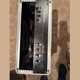 Černý kytarový zesilovač v hliníkovém transportním kufru. Na přední straně je zlatý nápis Mesa BOOGIE a model Fifty/Fifty s doplňkem STEREO TUBE POWE…