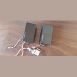 Dvě černé elektrické kytarové snímače s nápisem Seymour Duncan. Jsou vybaveny připojovacími kabely a k nim je přiložen jeden potenciometr s připojený…