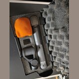 Černý mikrofon s kovovou mřížkou v černé polstrované přepravce. Na těle mikrofonu je bílý nápis AKG C 1000 S a AUSTRIA. Součástí je černý držák a ora…