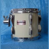 Bílý buben s chromovaným kováním a obručemi. Na korpusu je nalepený štítek s nápisy YAMAHA, MODEL RECORDING a MADE IN JAPAN. Povrch nástroje i kování…