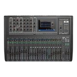 Černý mixovací pult s nápisem Soundcraft a modelem Si impact. Horní část obsahuje řadu otočných knoflíků, sekci dbx a displej s grafem. Spodní část j…