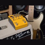 Žlutý kytarový efekt BOSS DD-200 HYBRID DRIVE umístěný na zesilovači Deluxe Reverb-Amp. Zařízení má několik ovládacích knoflíků, přepínač ON/OFF a ná…