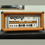 Kytarový zesilovač v oranžovém vinylu s bílým předním panelem. Na panelu je velký nápis ORANGE a označení modelu TH30 spolu s logem. Zesilovač obsahu…