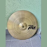 Kruhový mosazný činel s koncentrickým žebrováním povrchu. Na pravé straně je černý nápis pAiste a logo pst 3, pod kterým je text 18" CRASH RIDE. Povr…
