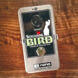 Stříbrný kytarový efekt s černým čelem. Na čele je bílý nápis SCREAMING BIRD TREBLE BOOSTER, nad kterým je umístěn černý otočný knoflík s nápisem BOO…