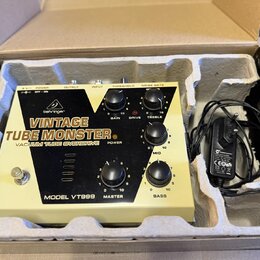 Kytarový pedál v krabici s polystyrenovými vložkami a přiloženým napájecím adaptérem. Na zařízení je bílý nápis VINTAGE TUBE MONSTER VACUUM TUBE OVER…