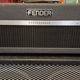Kytarový kombo zesilovač v černém látkovém potahu. Na horní části je logo FENDER a na stříbrném pásu nápis BASSBREAKER. Pod nápisem se nachází černá…