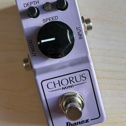 Fialový efekt pedál s nápisy CHORUS MINI a Ibanez. Na horní části jsou tři černé ovládací knoflíky s popisky DEPTH, LEVEL a SPEED, přičemž knoflík SP…