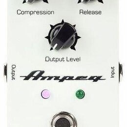 Bílý efekt pedál s třemi černými otočnými knoflíky označenými jako Compression, Release a Output Level. Na spodní části je logo Ampeg, dvě kontrolky…