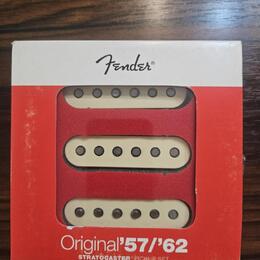 Krabice s sadou tří snímačů pro kytaru Stratocaster v krémové barvě. Na horní části krabice je černý nápis Fender®, ve spodní červené části bílý text…