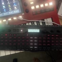 Černý sekvencer KORG SQ-64 s mřížkou červeně podsvícených tlačítek. Na horním panelu je digitální displej a nápisy TRANS P.LY/ARP SCALE ADD GATE EQUA…