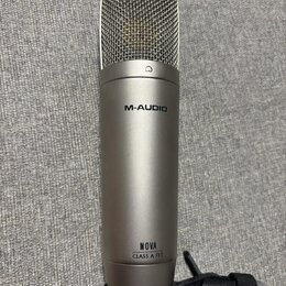 Stříbrný kondenzátorový mikrofon s kovovou síťkou v horní části. Na těle je uveden nápis M-AUDIO a dále text NOVA CLASS A FET. Mikrofon je umístěn v…