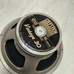 Kruhový reproduktor s kovovým rámem v šedé barvě. Na středovém černém štítku s gold okrajem je uveden nápis CELESTION, G12 Vintage 30 a 16 ohms. Okra…