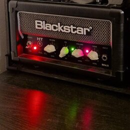 Černý kytarový kombozesilovač značky Blackstar z řady HT MkII. Na předním panelu jsou bílé a zelené ovratové knofíky s popisky POWER, REVERB LEVEL, E…