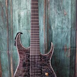Elektrická kytara s tmavým, mramorovaným povrchem těla a černým hmatníkem. Na hlavě je bílý nápis Ibanez. Nástroj má dva humbuckery, jeden ovládací k…