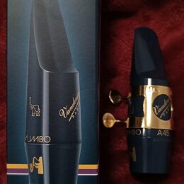 Na fotografii je modrý saxofonový munční kus s mosazným stiskovacím prstencem a krabička. Na krabičce jsou nápisy BLUE EBONITE, SAX. ALTO Mib - Eb a…