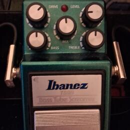 Zelený kytarový efekt pedál značky Ibanez. Na horní části jsou čtyři ovládací knoflíky s popisky DRIVE, LEVEL, BASS a TREBLE a jeden centrální knoflí…