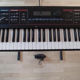 Černý digitální klavír s bílými a černými klávesami. Na pravé straně jsou ovládací prvky, displej a nápisy Roland a JUNO-D. Nástroj je umístěn v čern…
