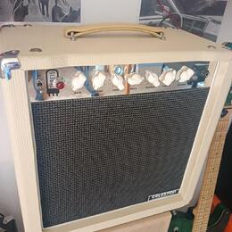 Kytarový kombozesilovač v krémovém vinylu s černou textilní maskou a světlou rukojetí. Na předním panelu jsou bílé ovládací knoflíky a nápisy GAIN, V…