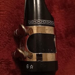 Černý munzmund s kovovým stahovacím prstencem v zlatavé barvě. Na spodní části je vyryto „6“ a symbol hvězdy. Povrch munzmundu je hladký a lesklý, ko…