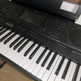 Černý digitální klavír značky YAMAHA, model PSR-SX700. Nástroj má bílé a černé klávesy, ovládací panel s displejem, několika tlačítky a voličem. Povr…