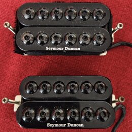 Dvě černé humbuckerové snímače s černými plastovými kryty a viditelnými póly. Oba mají na spodní části bílý nápis Seymour Duncan. Snímače jsou umístě…
