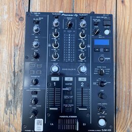 Černý DJ mixér s nápisem Pioneer DJ a označením modelu 2 CHANNEL DJ MIXER DJM-450 v pravém dolním rohu. Zařízení obsahuje zahlreiche potenciometry, p…