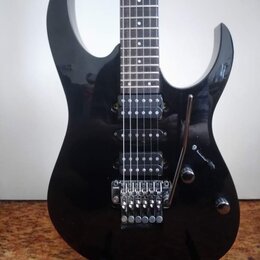 Černá elektrická kytara s lesklým povrchem a dvěma hlubokými výřezy v korpusu. Nástroj je vybaven dvěma humbuckery, Tremolo mostem a třemi ovládacími…