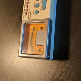 Bílý ladicí přístroj s modrým rámem a analogovým displejem. Na horním panelu jsou nápisy BOSS, CHROMATIC TUNER a TU-12H Digital Processing. Zařízení…