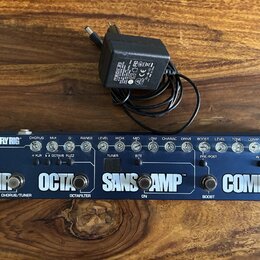 Modrý basový efektový pedál s nápisem BASS FLY RIG a TECH 21. Na předním panelu jsou ovládací knoflíky, přepínače a nápisy CHORUS/TUNER, OCTAFILTER,…