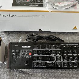 Černý analogový polyfonní syntetizátor s nápisem Pro-800 a logem Behringer. Přístroj obsahuje řadu potenciometrů, tlačítek pro výběr programů a ovlád…