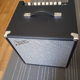 Černý kytarový kombo zesilovač s šedou textilní maskou reproduktoru. Na masce je umístěno logo Fender. Horní panel obsahuje řadu bílých oválných ovlá…
