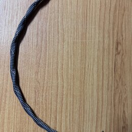 Černý audio kabel s pleteným obalem a konektory typu jack. Na spodním konektoru je hnědý kožený pásek s vyraženým nápisem sonorus a menším textem pod…