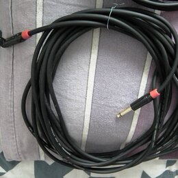 Černý instrumentální kabel s pravoúhlým a rovným konektorem typu jack. Oba konektory mají červené označení u základny. Na povrchu kabelu je viditelný…