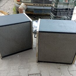 Dva černé reproduktorové boxy s šedou textilní maskou a světlými hranami. Povrch horníchdesek je černý, boční lišty vykazují známky opotřebení a koro…